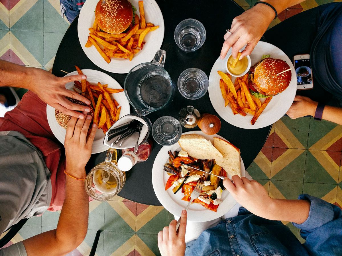 Guests sharing a meal around a restaurant table, seen from above