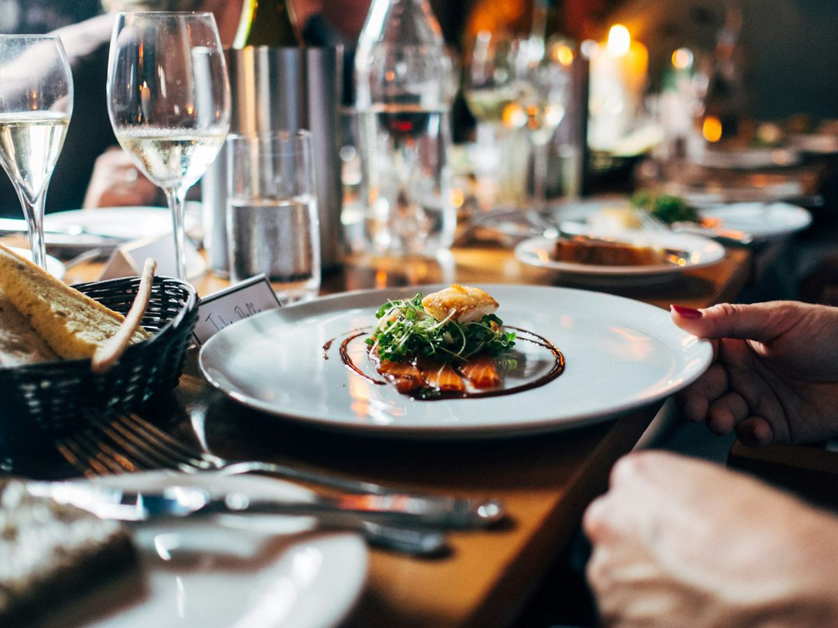 A plated dish being served at a full-service restaurant table
